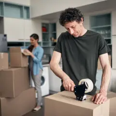 Mann packt Kartons für den Umzug. Bald wird er die umzugskosten steuerlich absetzen können.