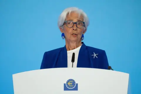 Christine Lagarde spricht über den EZB Zinsentscheid. Sie trägt eine blaue Jacke mit einem Seestern-Anstecker.