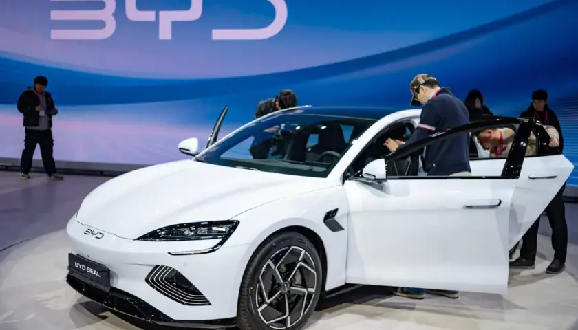 Weißer BYD Seal auf einer Messe, Leute steigen ein. Die BYD Aktien könnten bald steigen.