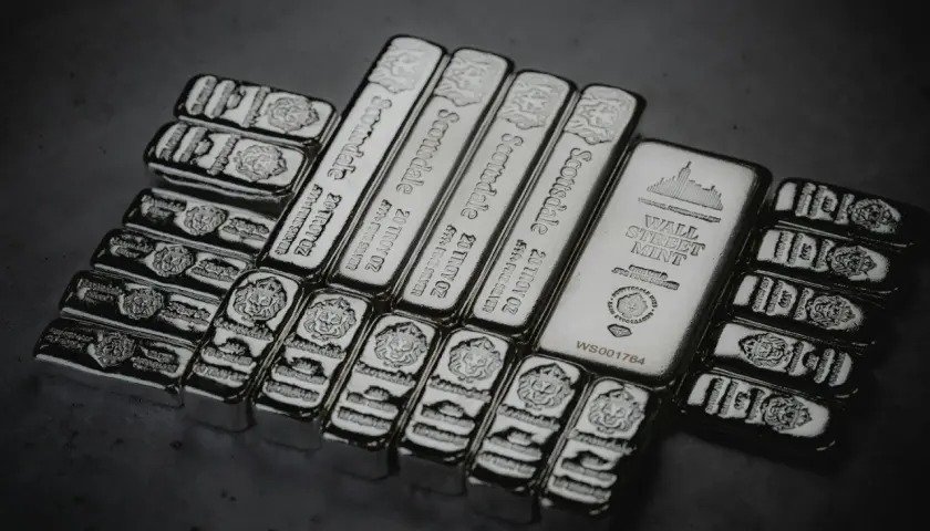 Mehrere Silberbarren, darunter Scottsdale 20 Troy oz und Wall Street Mint, glänzen im Licht.