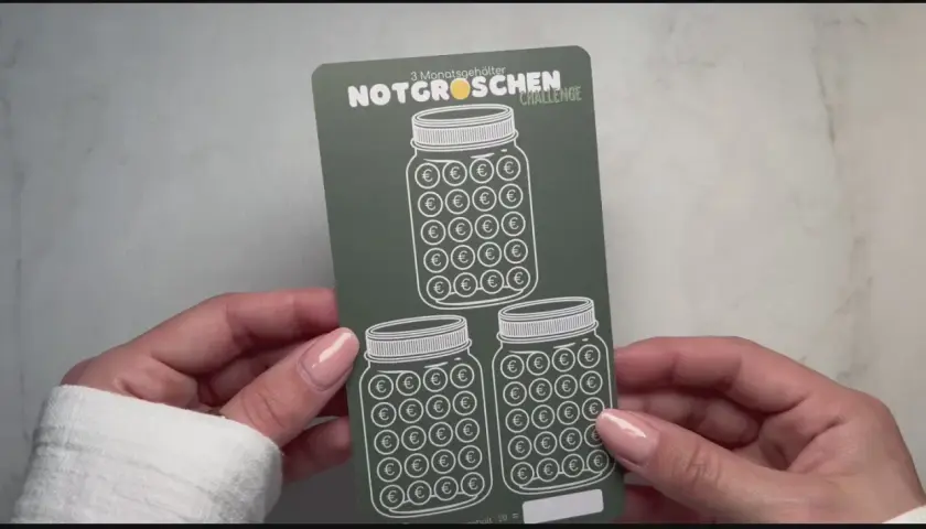 Hände halten eine "Notgroschen Challenge"-Karte mit drei Einmachgläsern, gefüllt mit Euro-Symbolen. Perfekt, um die eigene spar challenge selber machen zu starten!
