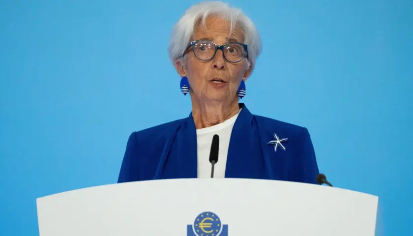 Christine Lagarde spricht über den EZB Zinsentscheid. Sie trägt eine blaue Jacke mit einem Seestern-Anstecker.