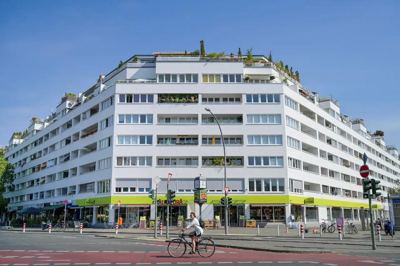 Modernes Wohnhaus mit vielen Balkonen und Geschäften im Erdgeschoss, ein Beispiel für attraktive Anlagen in offenen immobilienfonds.